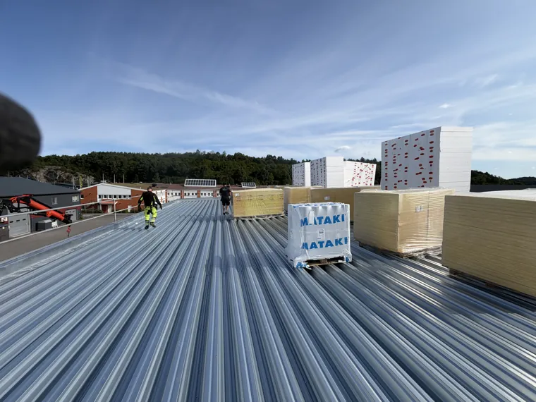 Ett större tak under uppbyggnad med plåt, isolering och tätskikt – bild 1